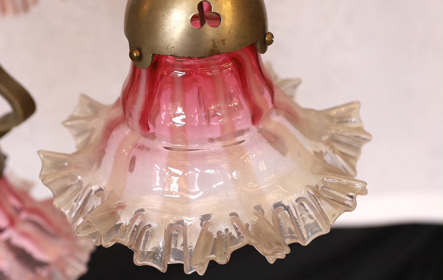 A 1930's Austrian silvered bronze four light chandelier decorated with stylised birds heads, with pink tinted frilled glass shades, height 94cm. width 52cm